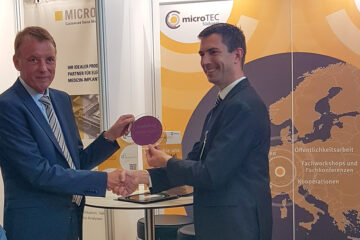Auf dem Bild sind Staatsminsiter Jörg Krauss links und Prof. Dr. Niels Quack Institutsleiter IMS CHIPS auf der Clusterkonferenz 2025 in Baden – Baden bei der Übergabe eines Wafers vom IMS CHIPS an Herrn Krauss zu sehen.