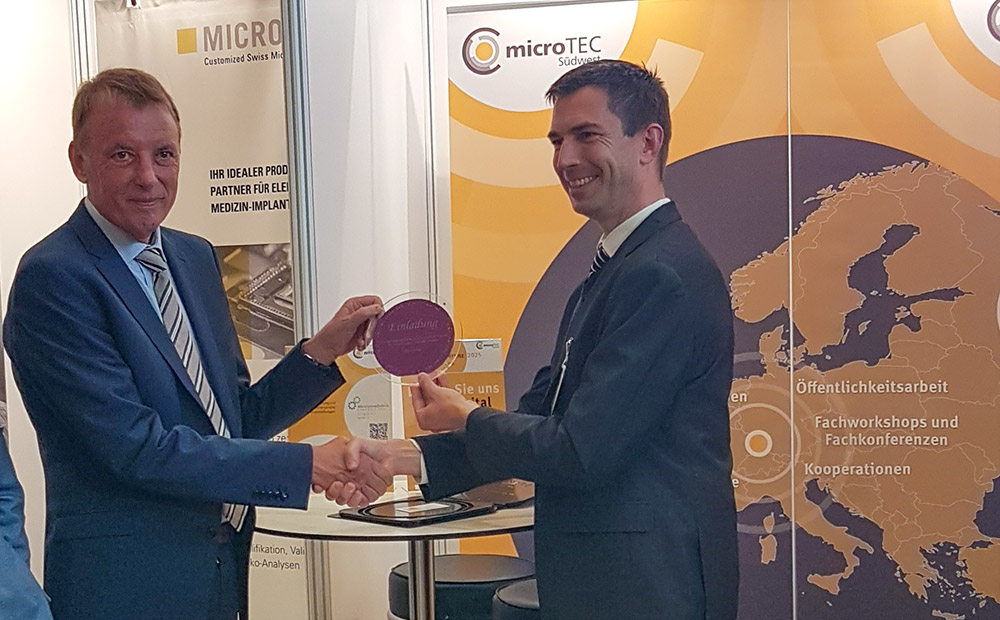 Auf dem Bild sind Staatsminsiter Jörg Krauss links und Prof. Dr. Niels Quack Institutsleiter IMS CHIPS auf der Clusterkonferenz 2025 in Baden – Baden bei der Übergabe eines Wafers vom IMS CHIPS an Herrn Krauss zu sehen.